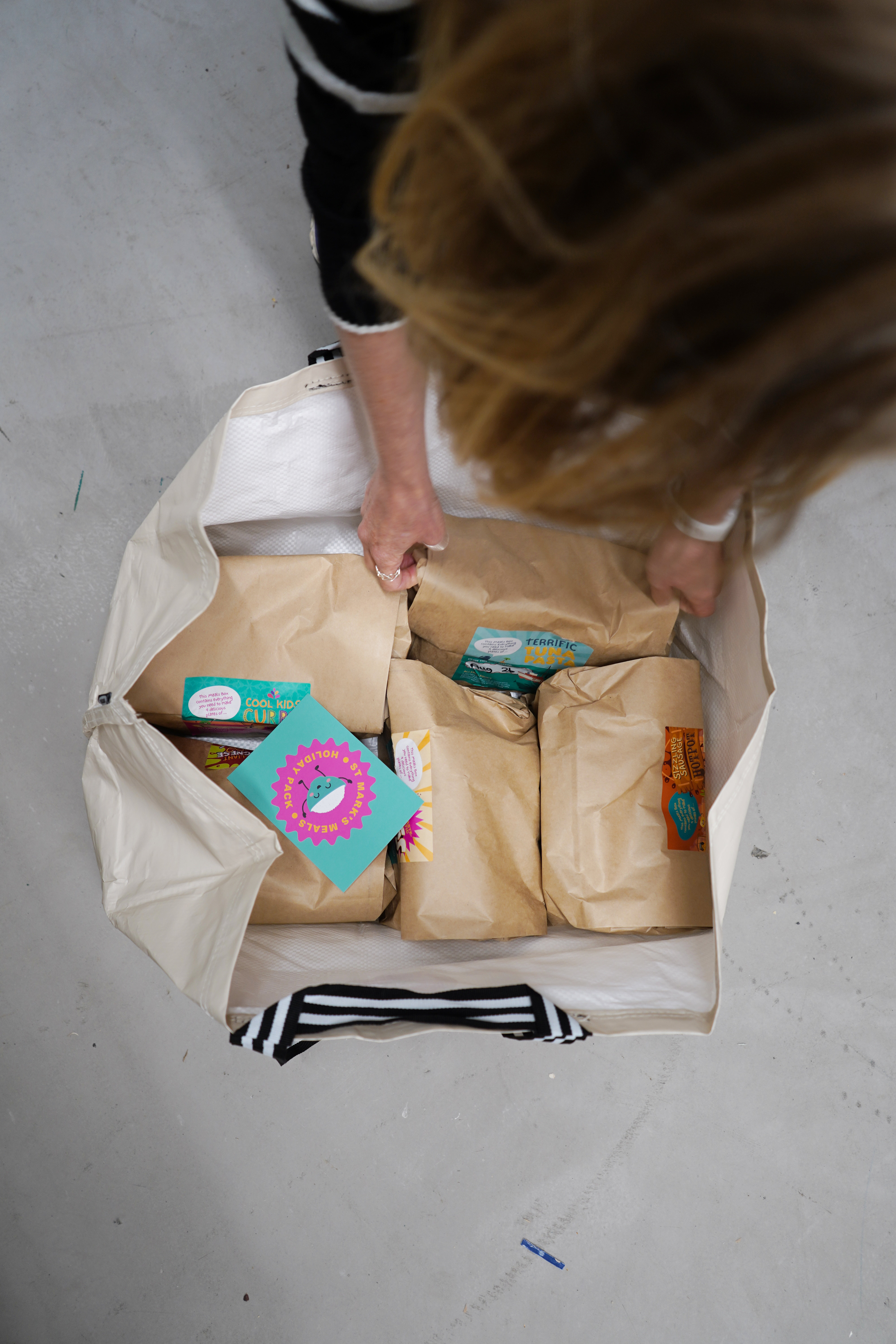 Woman opening holiday pack containing 5 meals in bags.